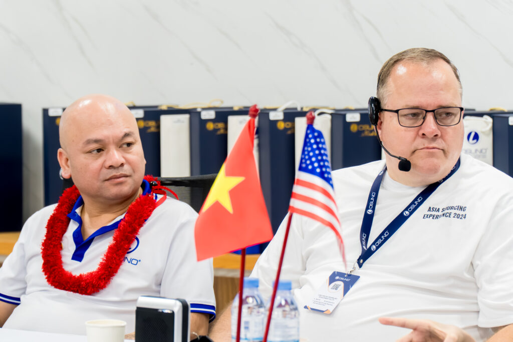 Ông Đỗ Mạnh Hải (trái) chủ tịch công ty TNHH PTCN Long Tiến Hải và ông PJ Roger giảng viên đại học BYU có cuộc trao đổi cùng các bạn sinh viên tại nhà máy OSUNO
